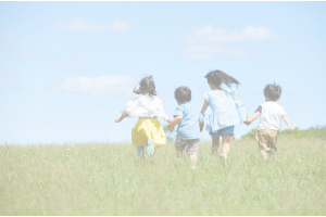 手を繋いで走っている4人の子どもたちの後ろ姿