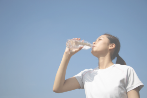 ペットボトルの水を飲む女性